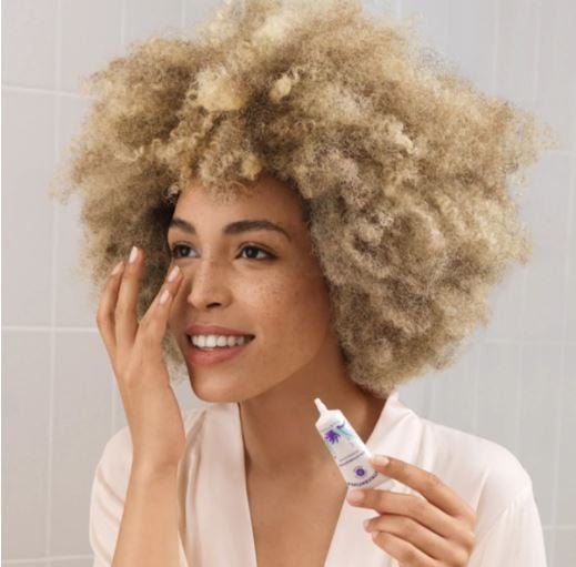 Frau trägt Ideal Eyes Augencreme von Nu Skin auf.