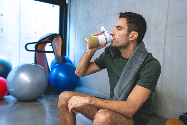 Man beim Sport trinkt Eiweißshake au Pharmanex Shaker Flasche