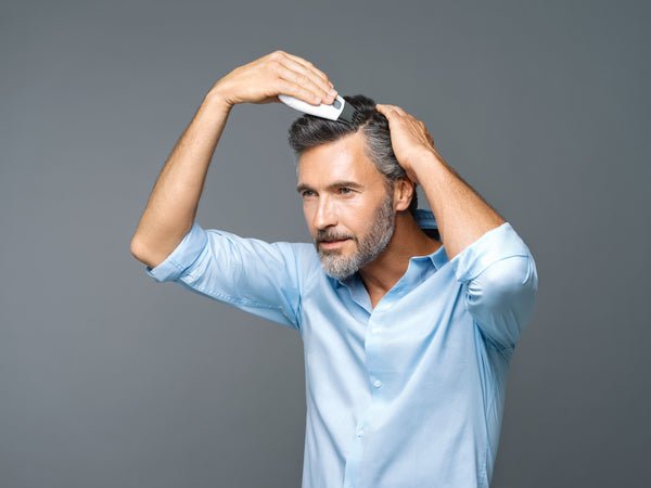 L'uomo usa Galvanic Spa per la crescita dei capelli
