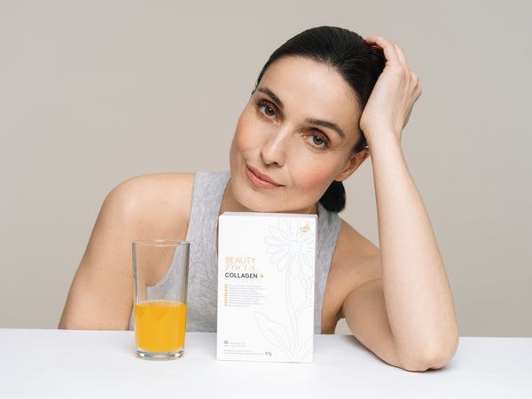 Femme avec un paquet de Collagen plus Nu Skin et un verre de boisson au collagène