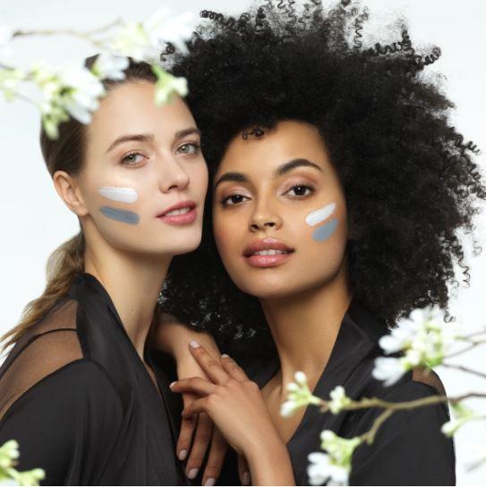 Zwei junge Frauen mit Yin und Yang Gesichtsmaske von Nu Skin