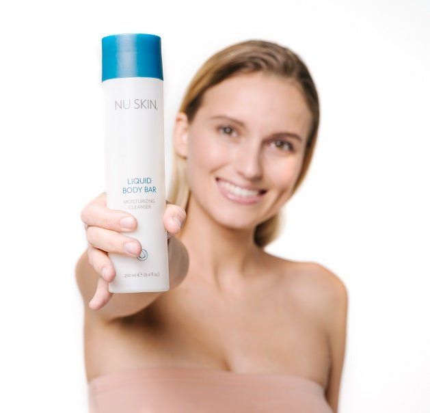 Mujer sosteniendo un paquete de Liquid Body Bar - exfoliante corporal de Nu Skin
